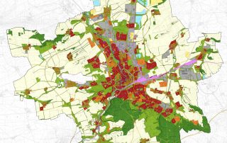Zu sehen ist eine Karte einer kommunalen Fläche mit Bereichen in verschiedenen Farben: grün, gelb, orange, pink, rot, grau, blau und beige. Rote Flächen überwiegen im Zentrum, nach außen hin sind es mehr grüne und beige Flächen.